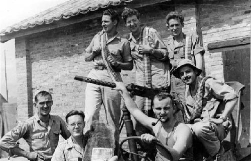 Soldier posing with large gun and ammunition