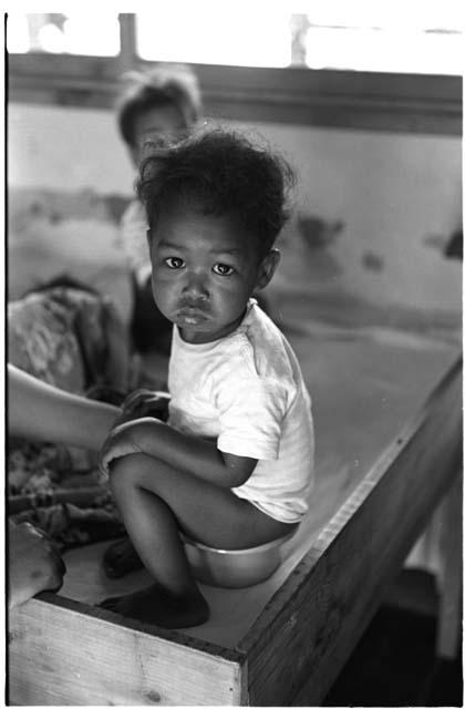 Small child sitting on a potty at an orphanage