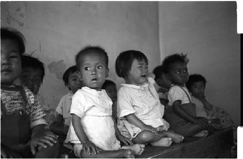 Group of sitting kids, one crying