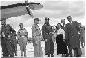 Military personnel standing beside plane