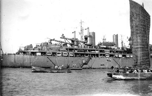 Boat sailing in front of large ship