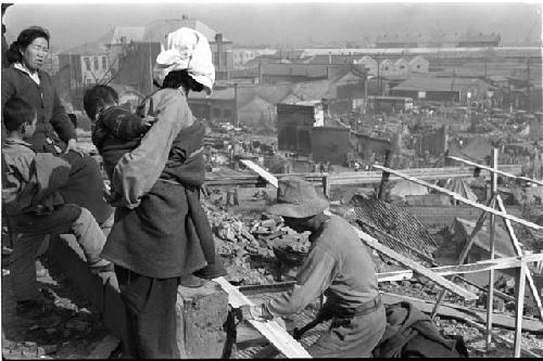 Back of woman's head holding child people at construction site