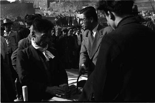 three men talking at a desk