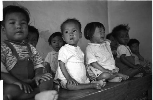 Group of sitting kids, one crying