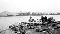 People preparing pontoon boat, camp furniture on shore