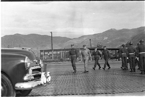 Men in uniform walking toward a car