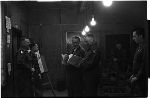 General Whitcomb and Colonel Slezak looking through pamphlet about the 226th Ordnance Base Depot