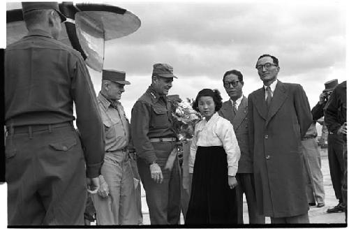 Military personnel standing beside plane