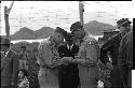 Military personnel standing beside a fence