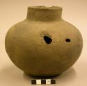 Ceramic vessel, short neck, two perforations in back.