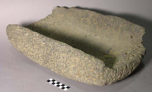 Metate, ground stone, rectangular, U-shaped in cross-section, pitted