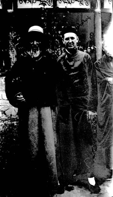 Three men standing in courtyard