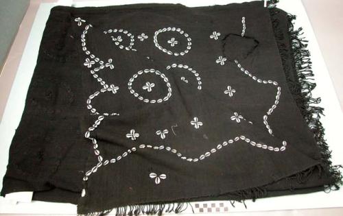 Black cloth with circles of cowrie shells, indicating number of heads +