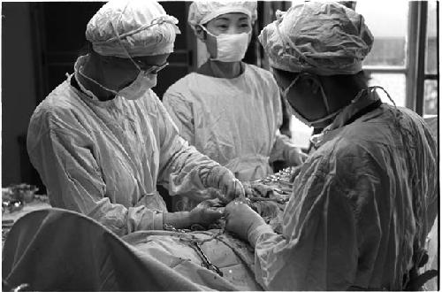 Three people performing surgery