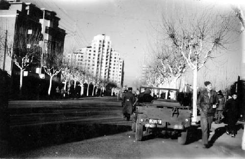 Man with Jeep on tree-lined street