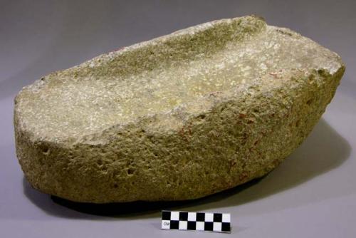 Metate, ground stone, ridges at either side at top, red accretions or pigment