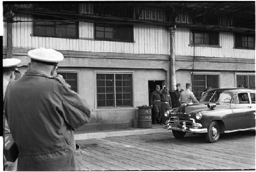 Men leaving a building and walking towards a car