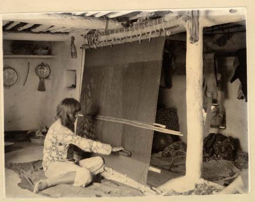 Hopi man weaving on a loom