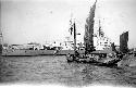 Boat sailing in front of large ship