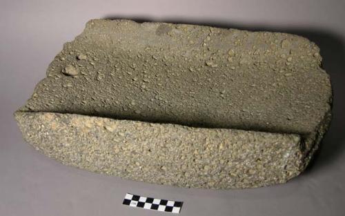 Metate. rectangular, open-ended trough. rounded bottom & sides. ground vesicular