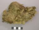 Animal hide with fur, some twisted into strands, dark brown