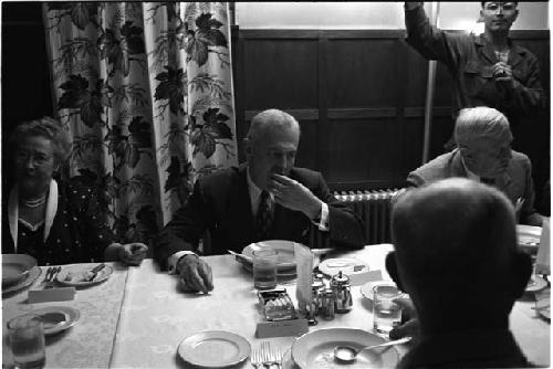 Man putting food in his mouth at a dinner table