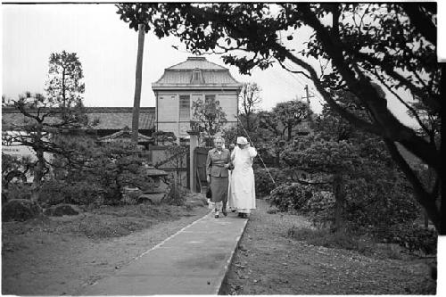 Nun walking with an elderly lady on a walkway