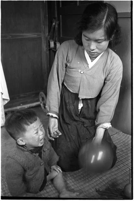 Woman kneeling beside a crying child