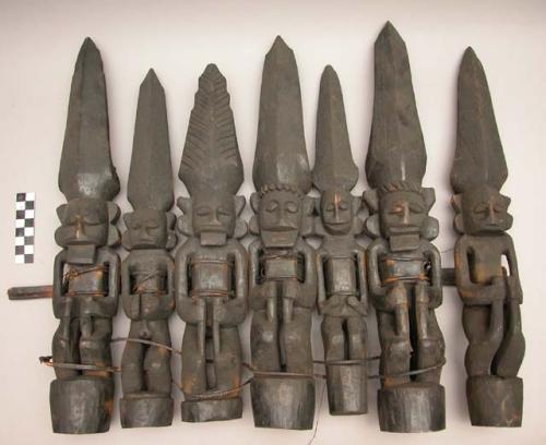 Group of 7 wooden ancestral images, bound together by wooden bar