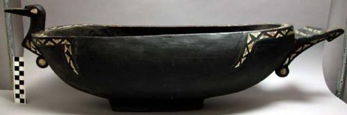 Wooden bowl in shape of bird, stained black, decorated with shell inlay