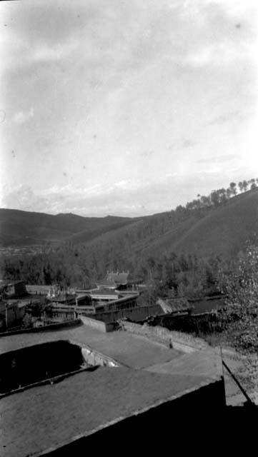 Roofs, other buildings and mountains in distance