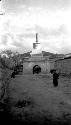 Stupa with archway, monk walking in front