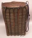 Woven carrying basket with tumpline; drawstring cover of commercial +