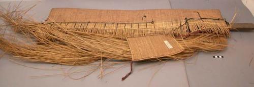 Partly woven mat with weaver's tools