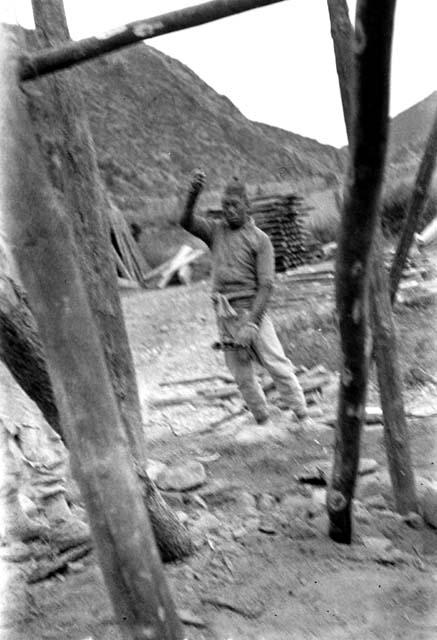 Chinese man holding string near wooden frame