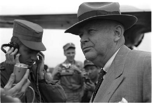 Microphone being held up to a man wearing a suit and hat