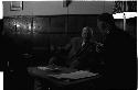 Two men in suits sitting in front of a low table