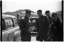 Military personnel beside a car