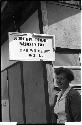 Woman standing beneath a sign