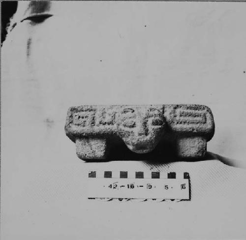 Small tetrapodal metate carved of coarse stone with a tiger head