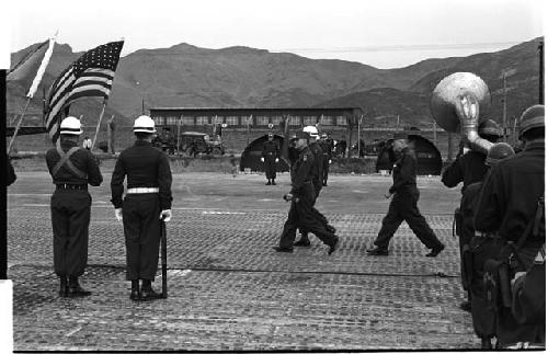 Soldiers at attention, one holding an American flag