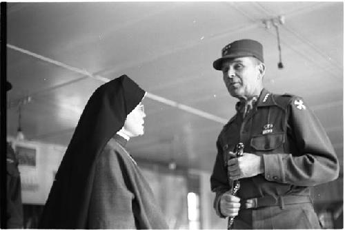 Nun speaking to a man wearing military clothing