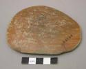 Ceramic sherd, red glaze, smoothed edges, oval shaped