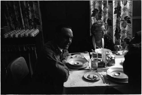 Man at a dinner table talking to the person at his right