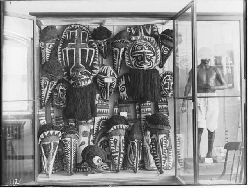 Historical photograph of masks in case at Peabody Museum