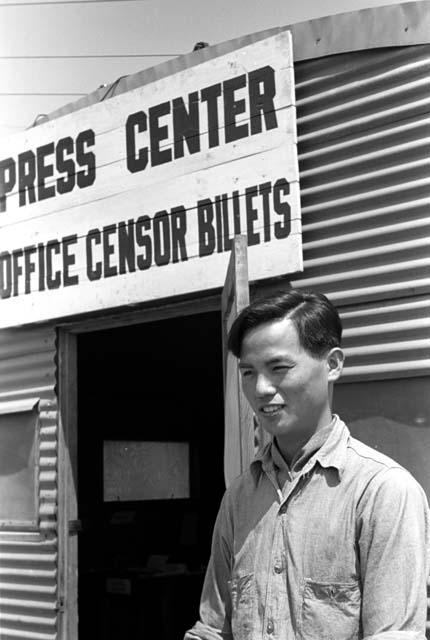 Man standing in front of building with "Press Center" sign