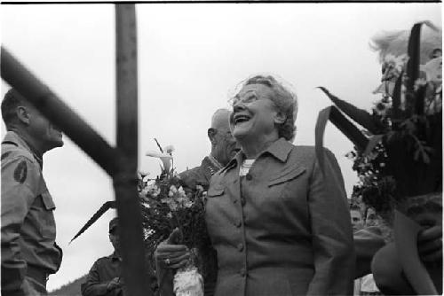 Woman holding flowers and looking happy