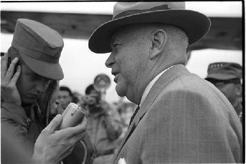 Microphone being held up to a man wearing a suit and hat