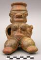 Hollow seated female effigy polychrome figurine with child in arms