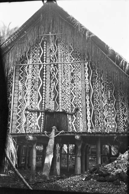 Temple on stilts with intricately painted facade and lizard sculpture